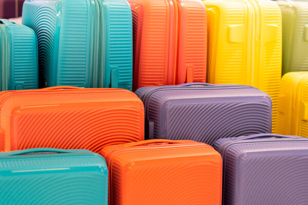 Стильные чемоданы на цветном фоне. Упакованные разноцветные чемоданы. Много разноцветных больших чемоданов или багажа. 