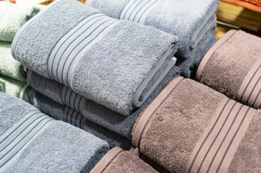 Mağazada renkli havlular yığını var. Mağazada bir sürü pamuk havlu var. Alışveriş anlayışı. Raflarda çok renkli havlular var..