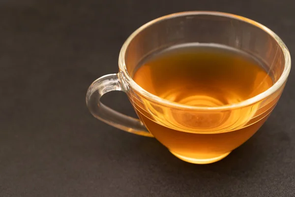 黒机の上に熱い生姜茶のグラスカップ — ストック写真