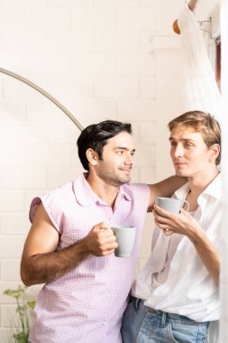 Lgbt gay çifti ellerinde kahve tutuyor. Evde kahve içen, eşcinsel gururu olan ve evlilik hayatı yaşayan iki eşcinsel. LGBT aşk konsepti.