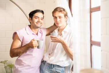 Lgbt gay çifti ellerinde kahve tutuyor. Evde kahve içen, eşcinsel gururu olan ve evlilik hayatı yaşayan iki eşcinsel. LGBT aşk konsepti.