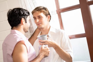 Lgbt gay çifti ellerinde kahve tutuyor. Evde kahve içen, eşcinsel gururu olan ve evlilik hayatı yaşayan iki eşcinsel. LGBT aşk konsepti.