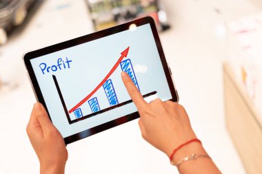 Mağazanın arka planı bulanık olan iş büyüme öntanımlı grafiğini görmek için tablet kullanmak. İş başarısı kavramı. Büyüme planlama ve strateji kavramı.