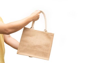 Beyaz arka planda jüt çanta ya da çuval tutan adam. Tekrar kullanılabilir bir alışveriş çantası. Plastiksiz. Çevre dostu kavram. Yeniden kullanılabilir alışveriş yaşam tarzları için çanta, ekoloji sektörü konsepti.