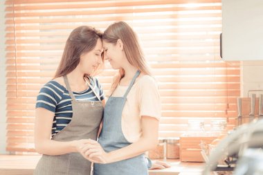 İçerde Lezbiyen Çift Konsepti. Lezbiyen mutfakta. Genç kadınların ortak bir lezbiyen aşk ilişkisi vardır. LGBT konsepti. sıcak ton.