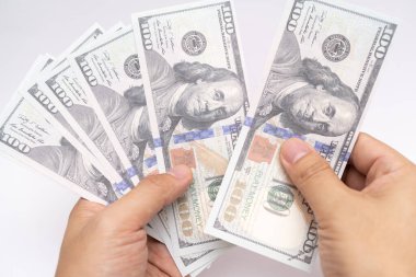 İşadamı 100 dolar nakit para sayıyor, mali ve planlama bütçesini kontrol ediyor. İş ve finans kavramı. Tahminler ve analizler. Yatırımlar.