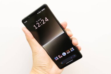 Bir Sony Xperia 1 işaret 5 ya da Sony Xperia 1V 'yi tutan el. Sony 'den yeni bir teknoloji. 4K HDR görüntülü Sony akıllı telefonu.