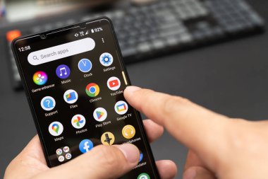 Elinde Sony Xperia 1 mark 5 ya da Sony Xperia 1V ile Youtube uygulamasını seçiyor. YouTube uygulaması kullanarak akıllı telefonu tutan eller.