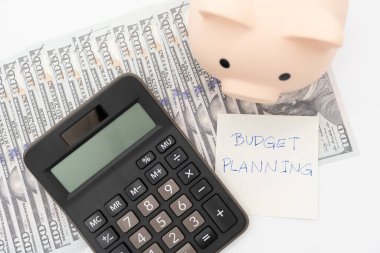 Money budget planning. Piggy bank with calculator on Dollars in isolated background. Finance and business concept.