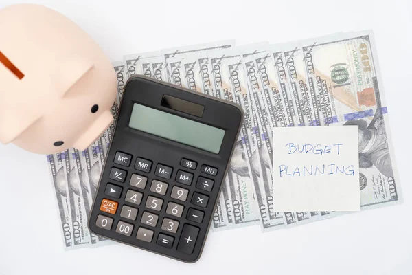 Money budget planning. Piggy bank with calculator on Dollars in isolated background. Finance and business concept.