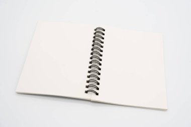Realistik, Pen ile birlikte defteri açtı. Metalik siyah spiralli dikey boş bir defter. Dizaynınız için not defteri yayıldı. Gölgelerin izole edildiği gerçekçi bir defter.