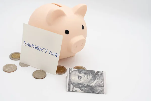 concept of emergency savings fund. A piggy bank with dollar and coins. piggy bank for saving emergency money.Saving for emergency concept. isolated background.