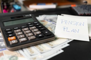 Kağıtlarda PENSION PLAN, Calculator, Pen yazılı. Yatırım Konsepti. Emeklilik Planı. Emeklilik konsepti. Emeklilik hesaplama kavramı.
