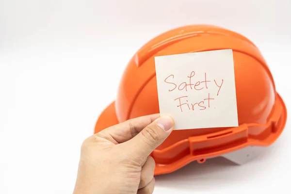 Руки Показывающие Текст Safety First Оранжевой Шляпой Безопасности Заднем Плане — стоковое фото