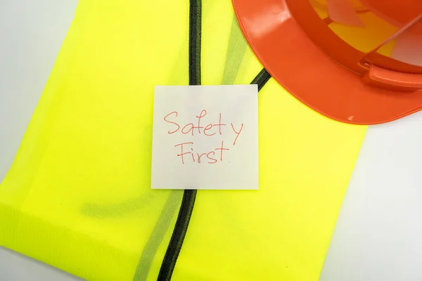 安全第一消息在纸上 安全齿轮 反光背心和安全帽或安全帽 安全第一概念 — 图库照片