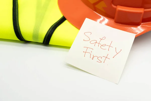 安全第一消息在纸上 安全齿轮 反光背心和安全帽或安全帽 安全第一概念 — 图库照片