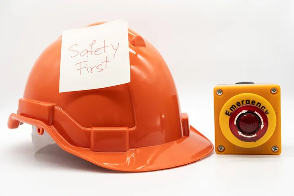 橙色安全帽与消息安全第一和紧急停止按钮隔离白色背景 安全第一概念 — 图库照片