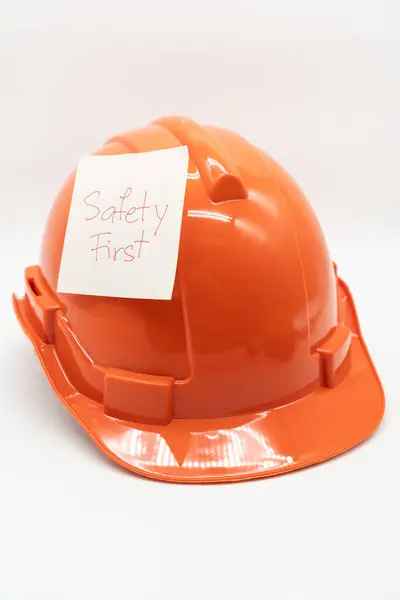 Pomarańczowy Kapelusz Bezpieczeństwa Wiadomością Safety First Twardy Kapelusz Izolowany Białym — Zdjęcie stockowe