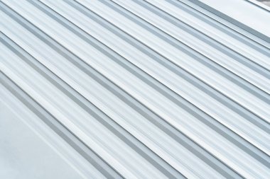 Alüminyum metal kaplama çatı. Metal alüminyum, gümüş, kıvrımlı şeritli, duvar arkası. Alüminyum metal kaplama çatı endüstrisi çatısı.