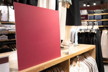 Alışveriş merkezindeki mesaj için kırmızı boş tabela. Alışveriş, iş modası ve reklam konsepti için alışveriş merkezindeki giyim mağazasının giyim markasının üzerinden reklam çerçevesi ayarı yapın..