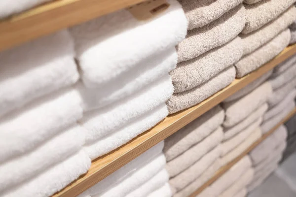 White towels on the shelves in the store. Stack of towels in a shop.