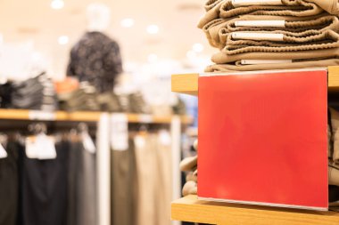 Alışveriş merkezindeki kırmızı boş tabela. Alışveriş, iş modası ve reklam konsepti için alışveriş merkezindeki giyim mağazasının giyim markasının üzerinden reklam çerçevesi ayarı yapın..