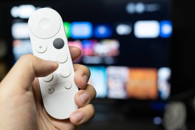 Televizyon izlemek için modern kumandayı tutuyorum..