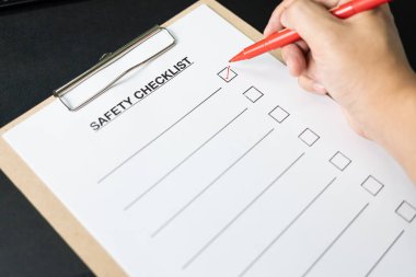 Güvenlik denetimi ve risk doğrulaması sırasında boş liste kağıtları. Güvenlik listesi formu kırmızı kalemle masanın üstünde..