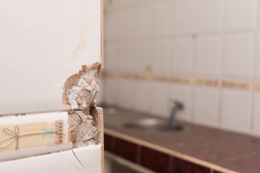 Kırık seramik fayans yüzeyine yakın çekim. Çatlak, kırık banyo duvarı kiremitleri veya paneller.