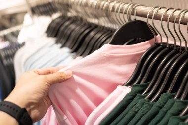 Erkek eli mağazadan indirimli gömlek seçerken, bit pazarından ucuz pamuk gömlek ararken ya da alırken. Erkek mağazada kıyafet seçer..