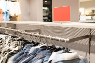 Alışveriş merkezindeki kırmızı boş tabela. Alışveriş, iş modası ve reklam konsepti için alışveriş merkezindeki giyim mağazasının giyim markasının üzerinden reklam çerçevesi ayarı yapın..