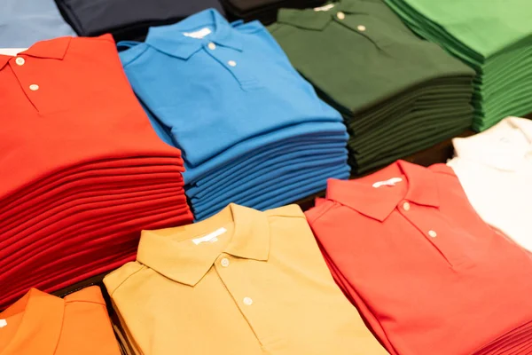multi colored clothes, polo shirt, shirt. Different colors polo shirt on the shelf.