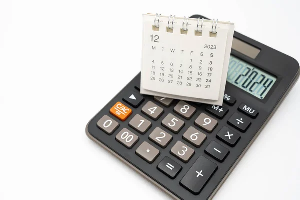stock image Calculator with the number 2024 on the display and Calendar DEC 2023. Concept of finance, taxes, savings and economic crisis. schedule, timetable and management of job. Business and tax concept.