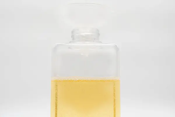 Pour yellow liquid through a funnel. Fill a dispenser with liquid soap or shampoo by pouring it from a refill to reduce plastic waste. Sustainable Zero Waste