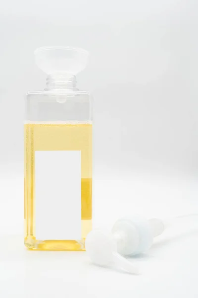 Pour yellow liquid through a funnel. Fill a dispenser with liquid soap or shampoo by pouring it from a refill to reduce plastic waste. Sustainable Zero Waste
