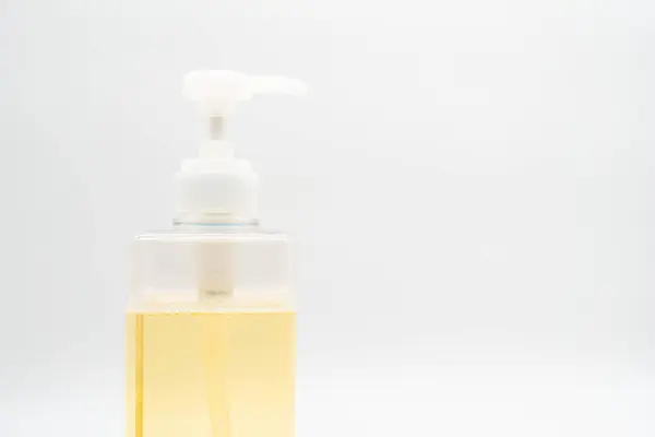 Yellow liquid soap or shampoo by pouring it from a refill to reduce plastic waste. Sustainable Zero Waste.