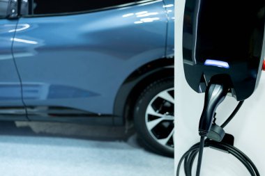 Elektrikli araba, kablolu ev yapımı şarj aleti. Elektrikli motoru olan bir araç için fiş. EV şarj aleti. Temiz enerji. Otoparkın şarj noktası. Gelecekteki ulaşım teknolojisi.