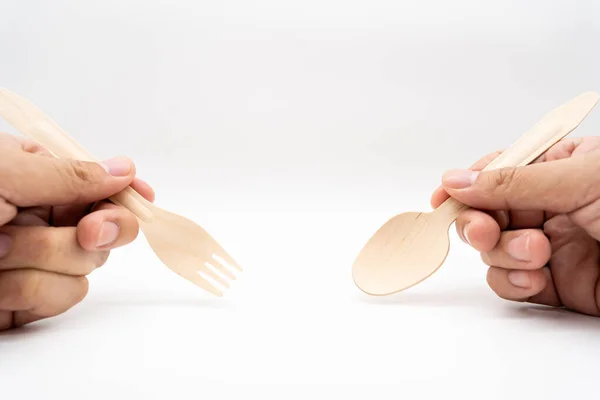 Hand holding Wooden Cutlery. Eco Tableware, Disposable Cutlery, Recycle. Eco food packaging concept, zero waste paper, sustainability.