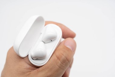 Kablosuz kulaklık tutan eller. Gerçekten kablosuz kulaklık açık bir dava üzerinde. Seçici odaklanma. Boşluğu Kopyala.