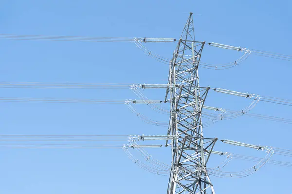 High electric tower isolated on blue sky background. A high voltage power pylons against blue sky.