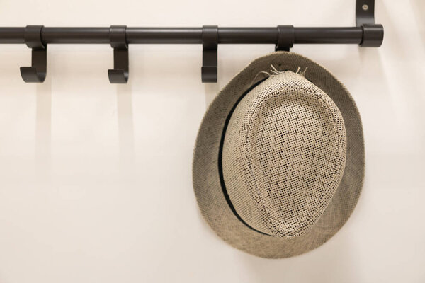 Санхат на вешалке для одежды. Шляпа висит на деревянном крючке для одежды в комнате. украшение дома на пляже.