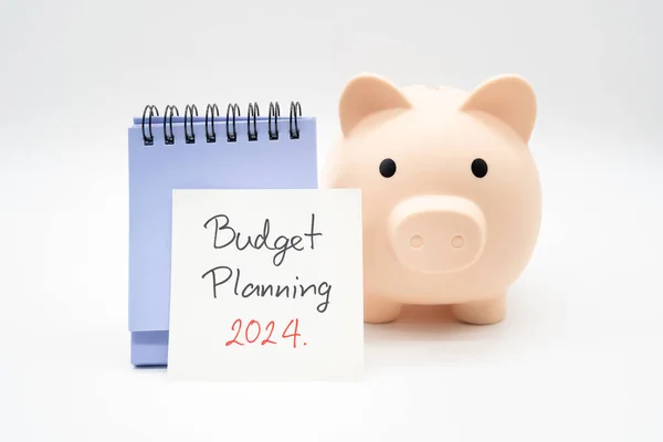 Budget Planning 2024 text message by hand writing on paper note, Calendar and Piggy bank. Budget planning concept.