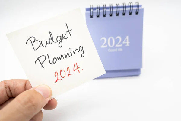 Budget Planning 2024 text message by hand writing on paper note and Calendar 2024. Budget planning concept. isolated on white background.