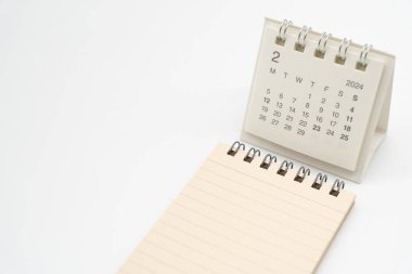 FEB 2024 için basit bir masa takvimi ve izole edilmiş boş bir not. Kopyalama alanı ile takvim kavramı.
