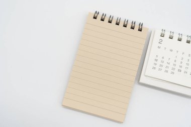 Kahverengi çizgili kağıtları ve FEB için izole edilmiş basit masa takvimi olan boş Spiral not defteri. Kopyalama alanı ile bellek kavramı.