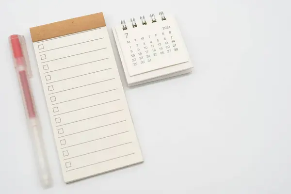 Blank Check list or Empty small notepad with checkbox and Simple desk calendar for JULY 2024. Blank checklist for text. Copy Space.