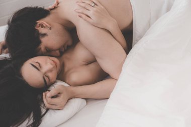 Yatak odasında Asyalı çiftin yan görüntüsü. Yatakta tutkulu bir çift. Sevgililer Günü. Sevgi ve mutluluğu birlikte hissetmek. Kavram: Aşk, seks, tatlım, tatlı, aktivite, yaşam tarzı. seçici odak