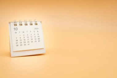 Ekim 2024 için turuncu arka planda izole edilmiş basit masa takvimi. Kopyalama alanı ile takvim kavramı.
