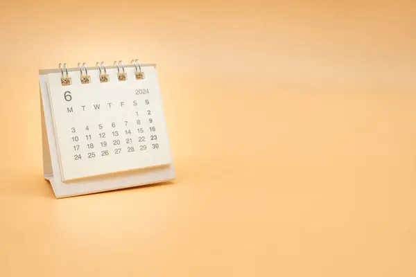 Simple desk calendar for JUNE 2024 isolated on orange background. Calendar concept with copy space.