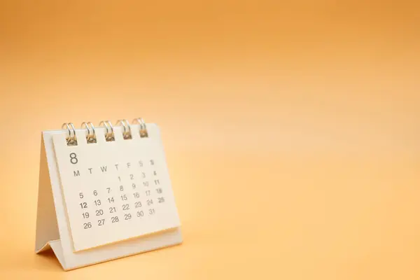 Desk calendar for AUGUST with no year isolated on orange background. Calendar concept with copy space. Desktop Calendar for Planner and management.